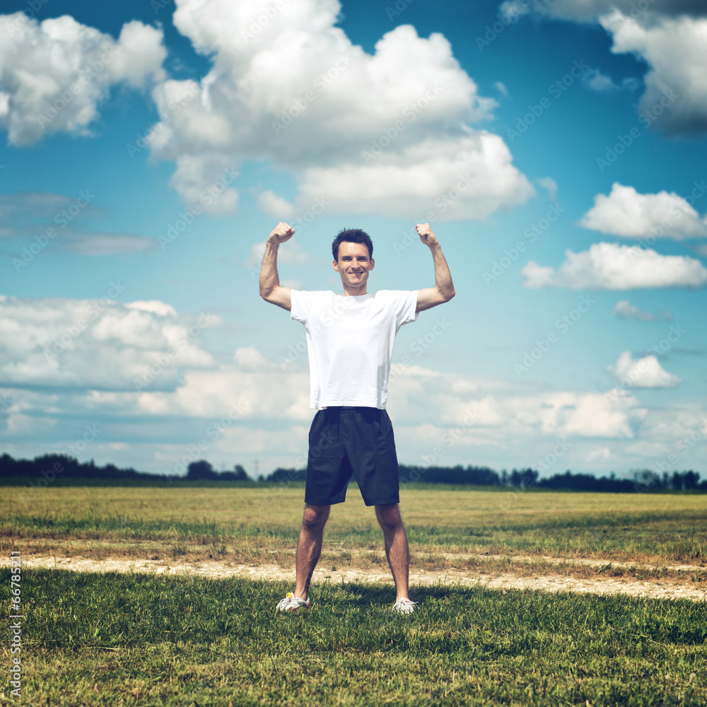 Happy athlete flexing his arm muscles Happy athlete flexing his arm muscles