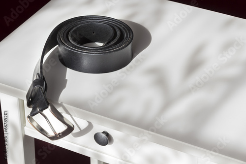 Фотография Mens belt on a bedstand