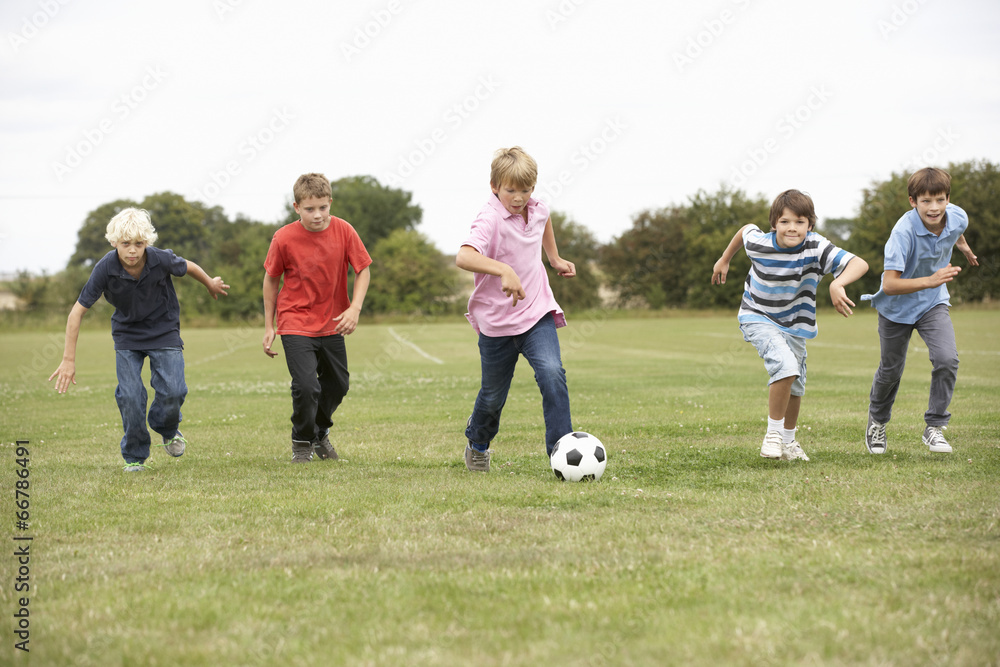 Boys playing with football in park Boys playing with football in park