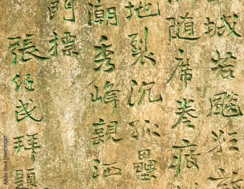 Ancient worn wall full of green chinese text