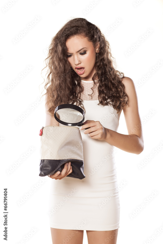 girl holding a magnifying glass and looking in her handbag girl holding a magnifying glass and looking in her handbag