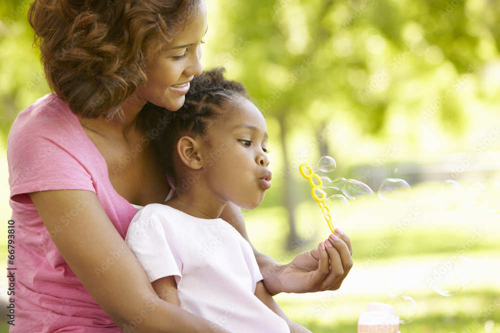 Fototapeta premium Mother and daughter blowing bubbles