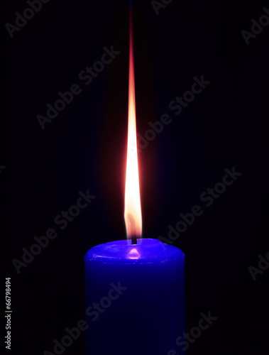 Closeup of burning candle on black background photo