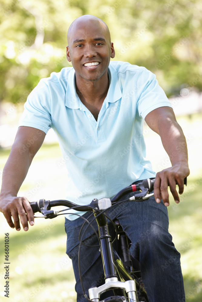 Young man cycling in park Young man cycling in park