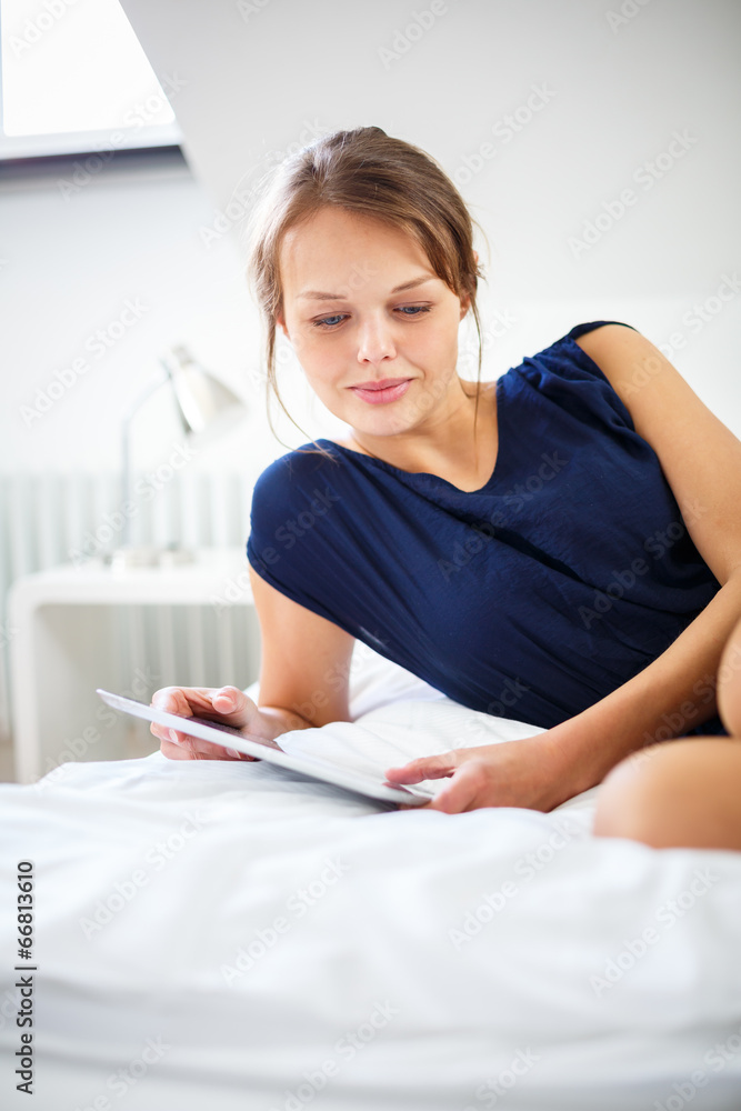 Elegant, smart, young woman using her tablet computer in bed Elegant, smart, young woman using her tablet computer in bed