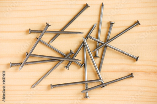 Heap of iron nails on wooden floor