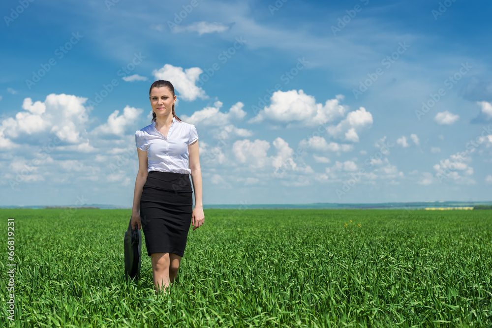 girl with a briefcase walking on grass