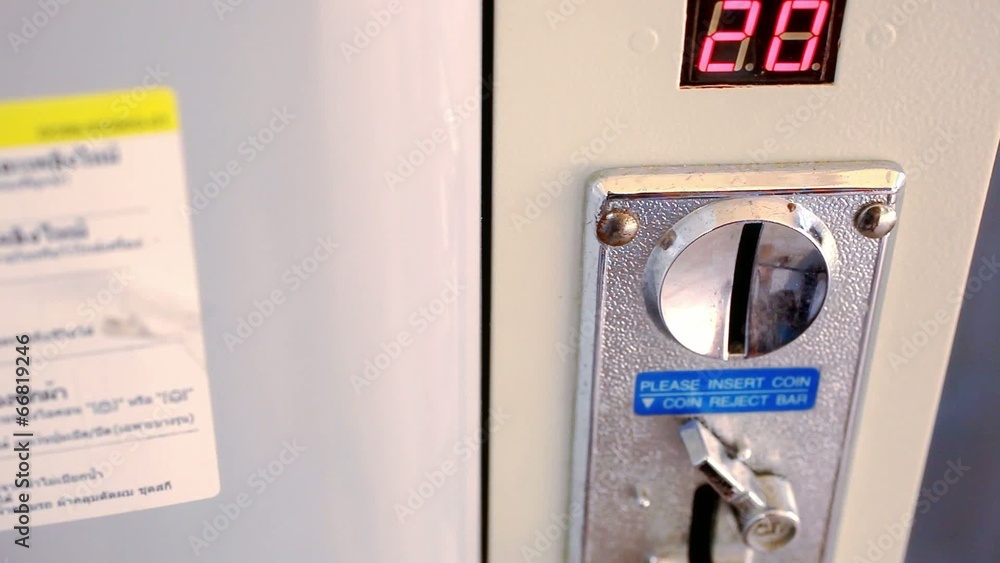 female hand throws coin in coin-operated washing machine female hand throws coin in coin-operated washing machine
