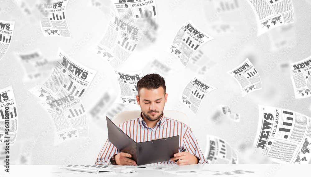 Business man at desk with stock market newspapers Business man at desk with stock market newspapers