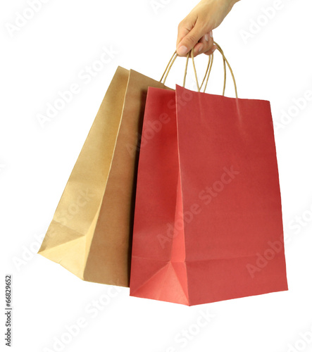 Woman hand carries shopping bags on white background.