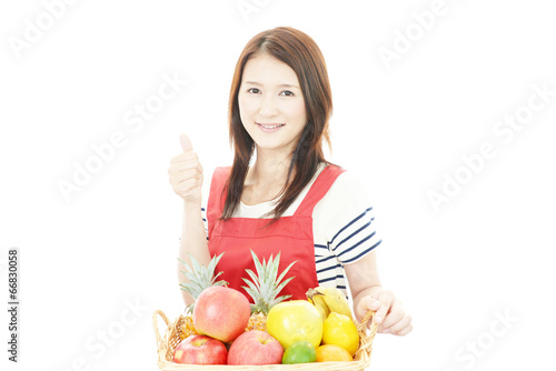 フルーツを持つ笑顔の女性