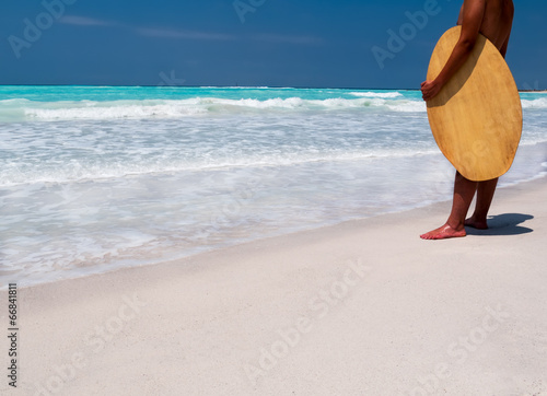Surfer standing on a tropical beach