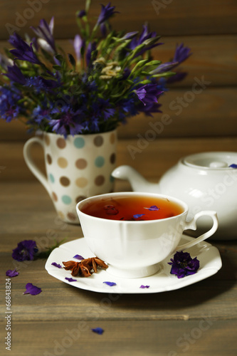 Cup of fresh herbal tea on wooden table