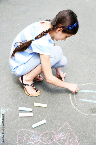 Cute girl drawing with chal...