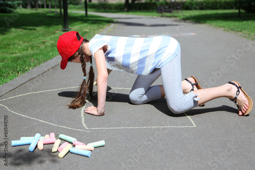 Cute girl drawing with chal...