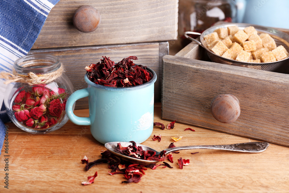 Dried hibiscus tea in color mug, brown sugar  in box