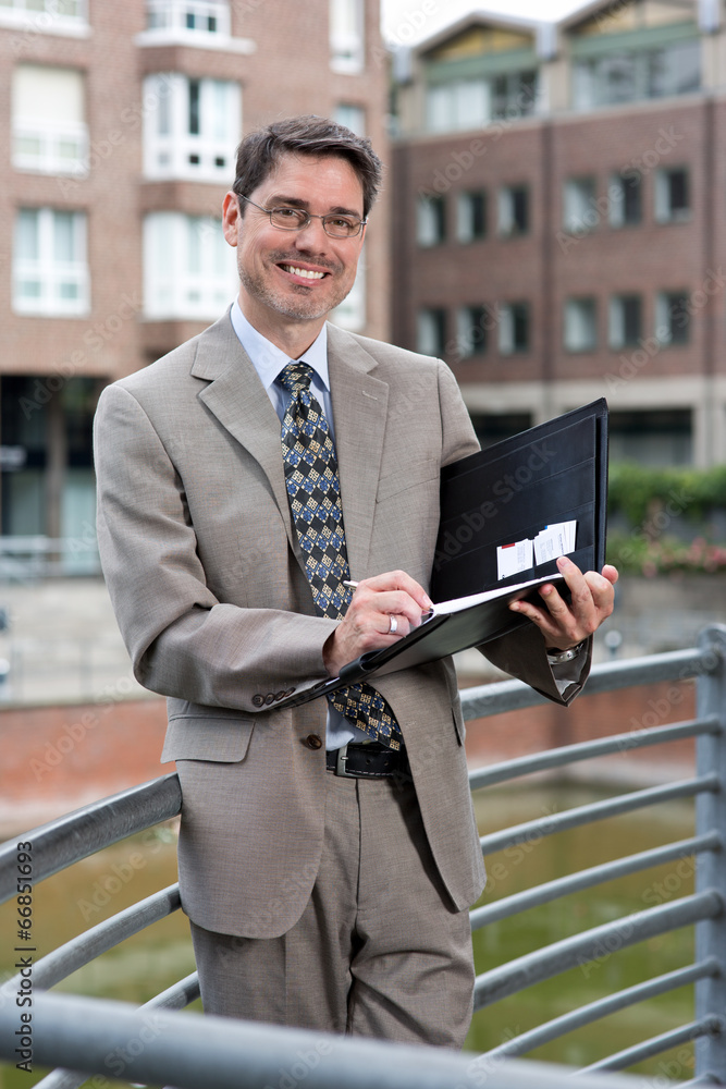 Fototapeta premium Manager mit Brille, Anzug und Unterlagen