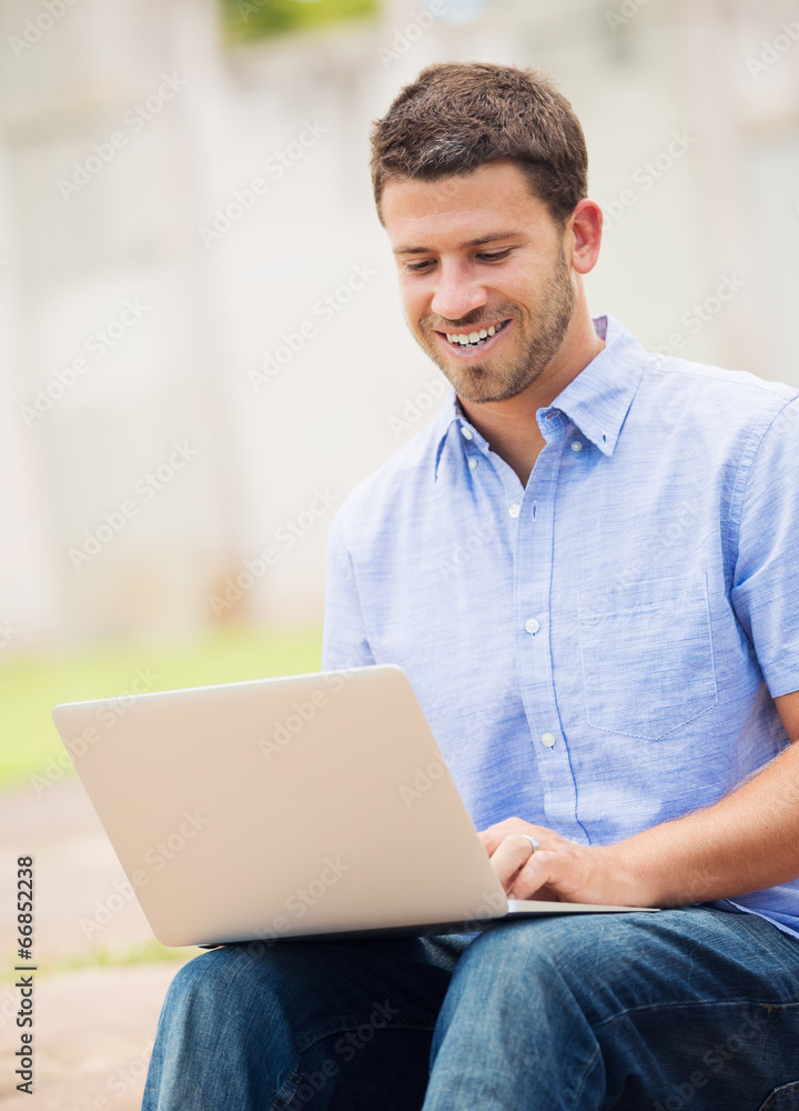 Young man working outside on laptop Young man working outside on laptop