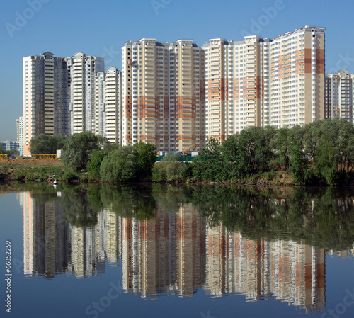 Many block of flats over river and clear blue sky