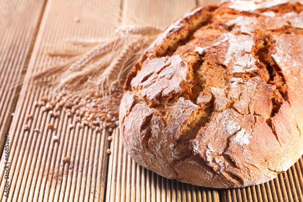 Fresh bread with wheat on the wooden background Fresh bread with wheat on the wooden background