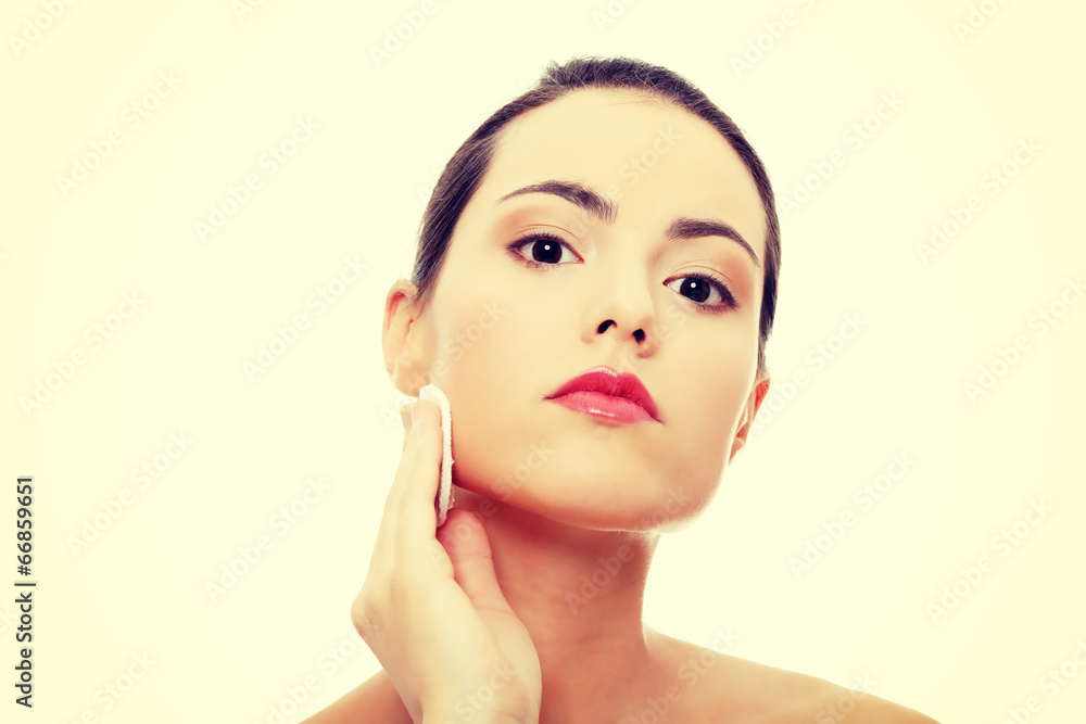 Young beautiful caucasian woman using a cotton pad Young beautiful caucasian woman using a cotton pad