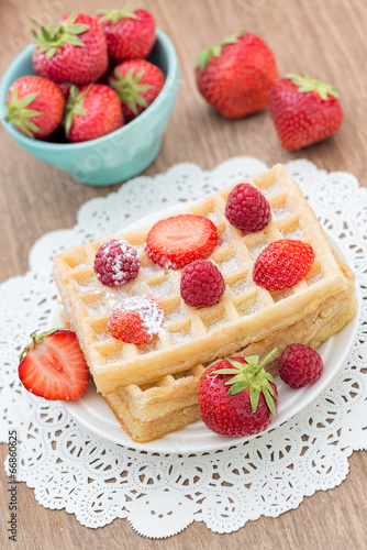 Delicious Belgian waffle with fresh berries for breakfast on woo