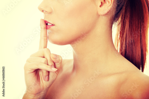 Billede på lærred Young woman gesturing for quiet