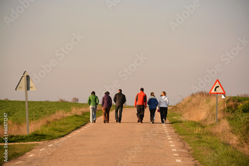 grupo de seis personas caminando por una carretera photo