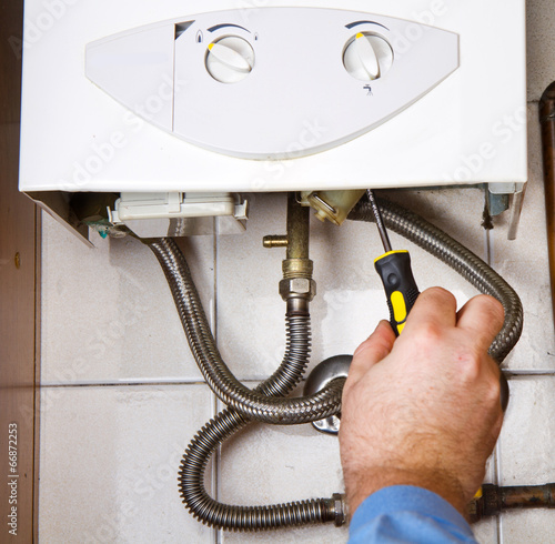 Plumber at work. Servicing gas boiler photo