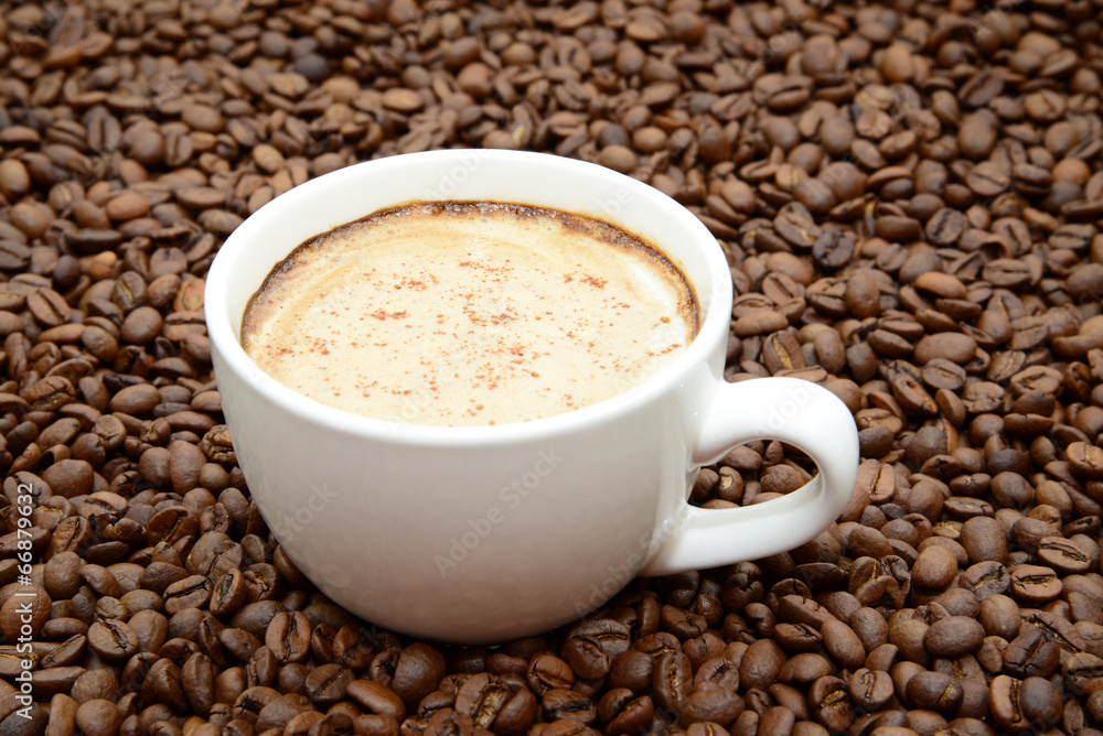 cup of coffee with cinnamon on a coffee beans background cup of coffee with cinnamon on a coffee beans background