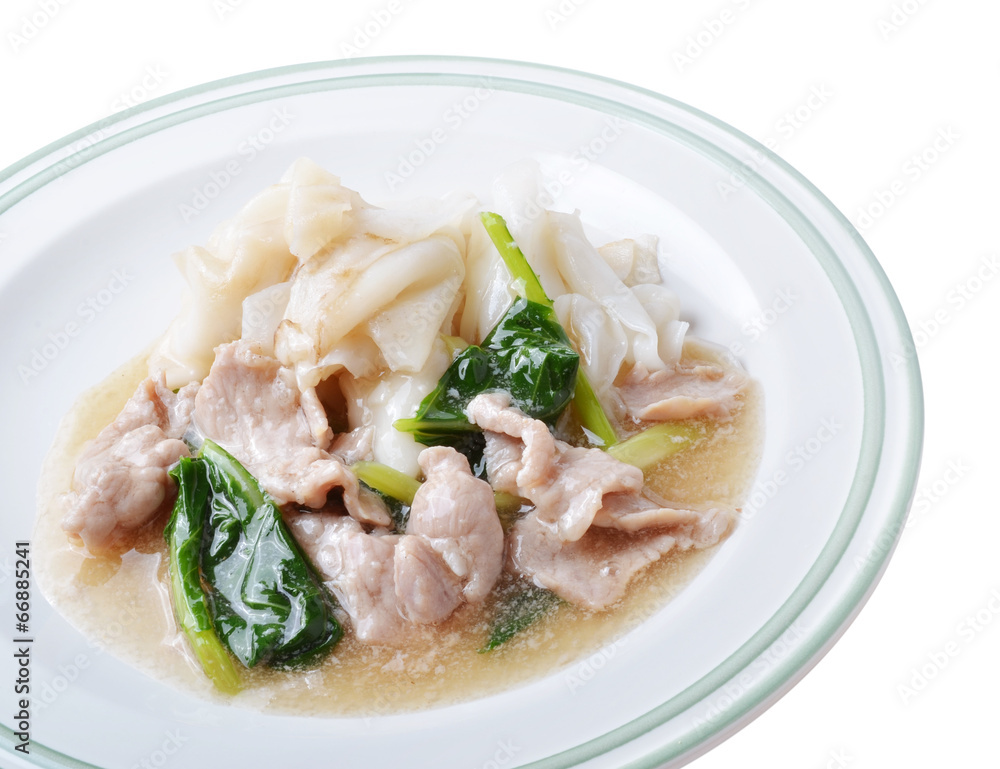 Noodle with pork and kale topping served in white bowl Noodle with pork and kale topping served in white bowl