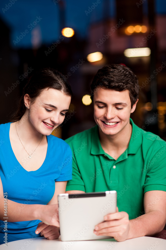 Couple using tablet computer at an outdoor cafe Couple using tablet computer at an outdoor cafe