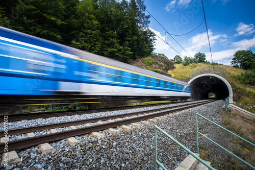 Fast train passing through a tunnel on a lovely summer day photo