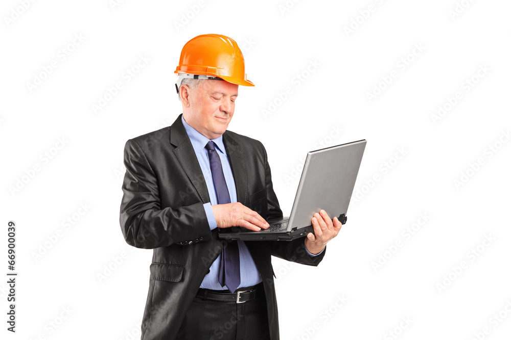 Mature construction worker working on a laptop Mature construction worker working on a laptop
