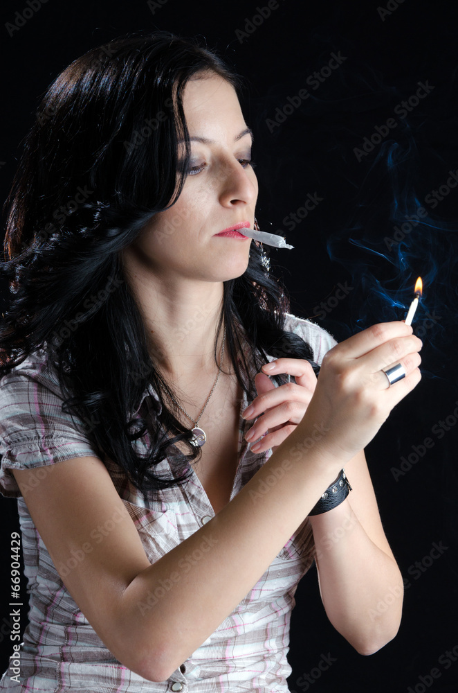 Fototapeta premium Woman Lighting Up a Cannabis Joint