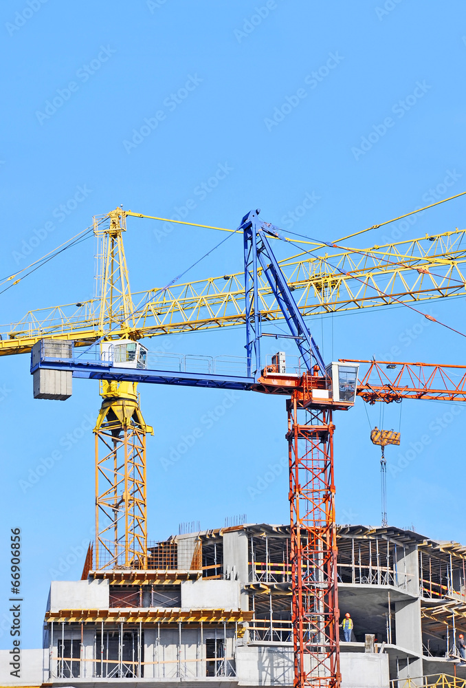 Crane and building construction site against blue sky