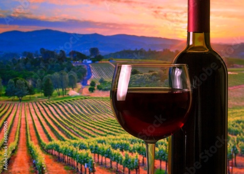 glass with red wine and bottle, atmosphere sunset