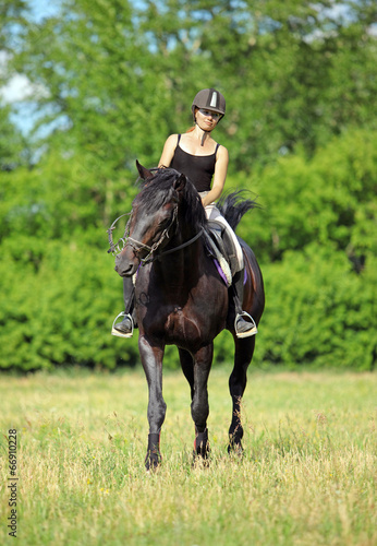 Caucasian girl riding horse in field