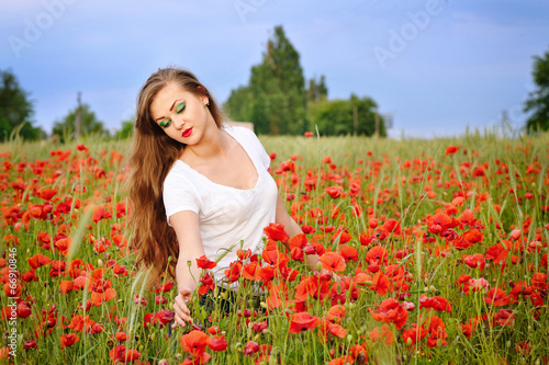 Young beautiful girl in a poppy field