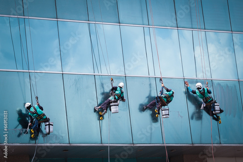 group of workers cleaning windows service on high rise building