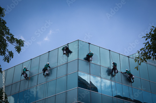 group of workers cleaning windows service on high rise building