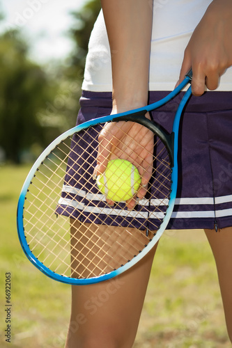 Female hand holding tennis racket