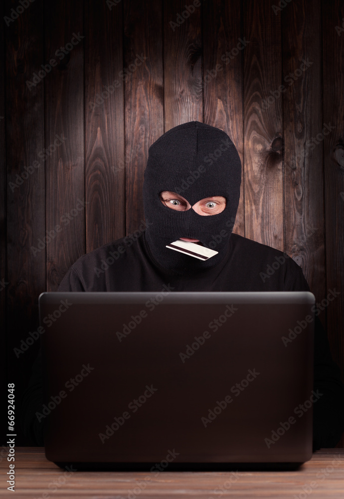 Hacker holding a credit card Hacker holding a credit card
