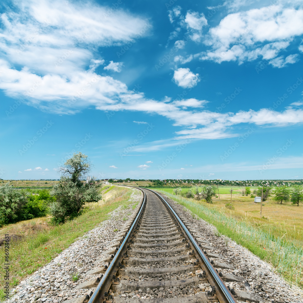 Obraz premium railway in green landscape and white clouds in blue sky