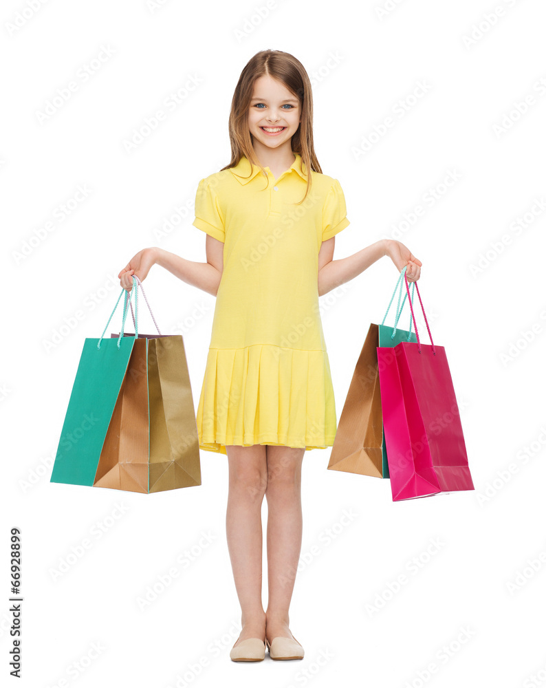 smiling little girl in dress with shopping bags