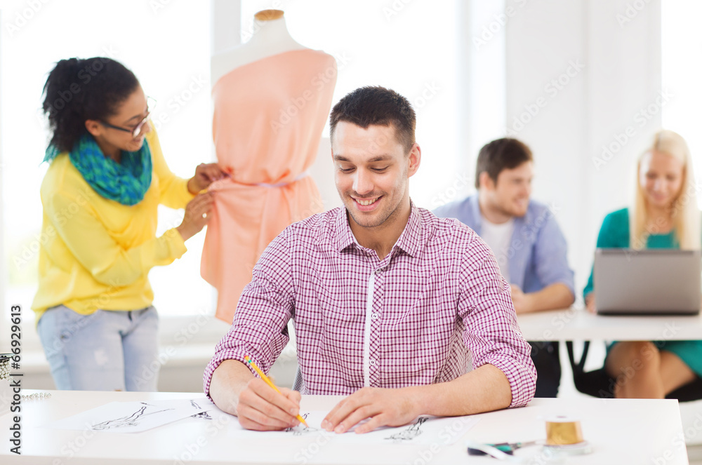 smiling fashion designers working in office