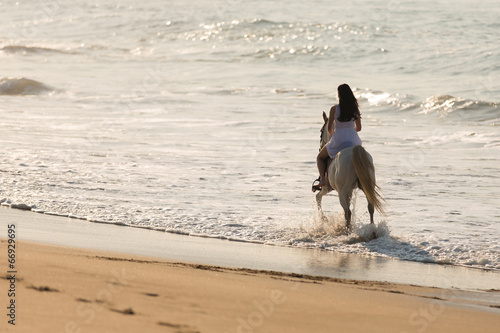 young lady horse ride on beach photo