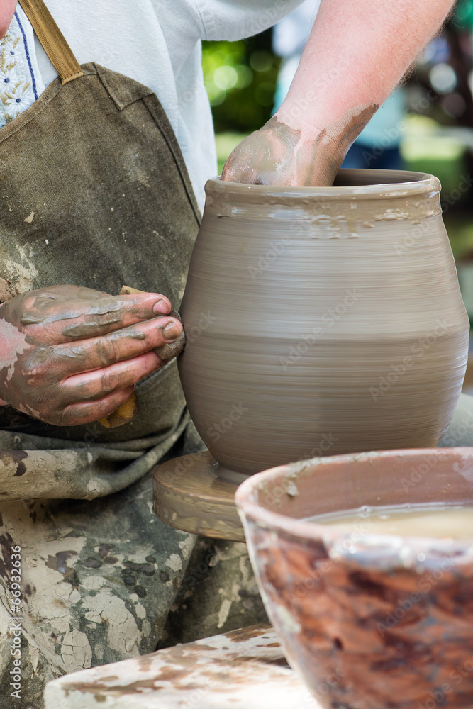 potter's hands working on ceramic jug