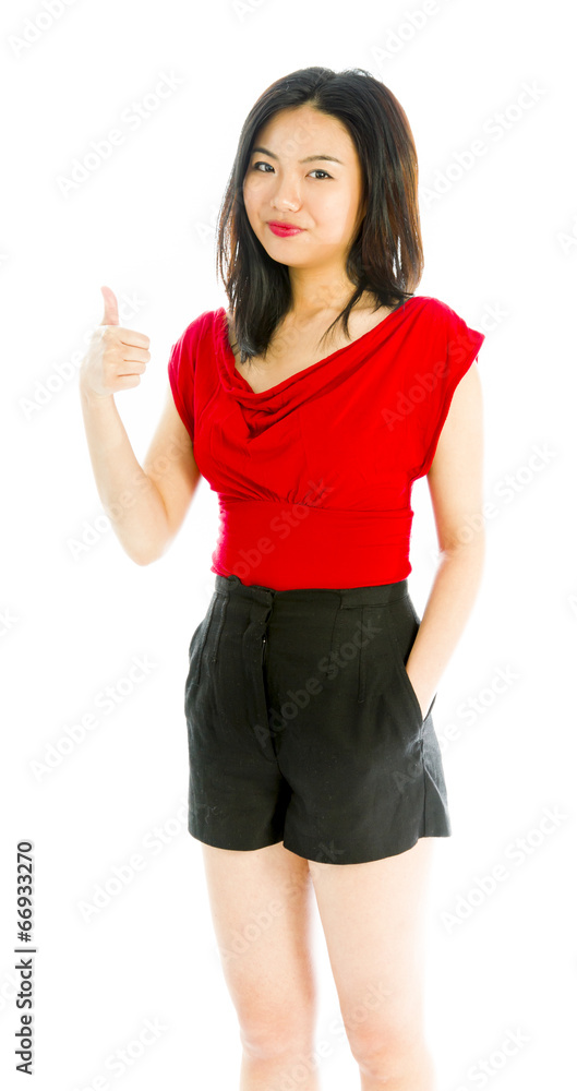 Young woman standing and showing thumbs up sign Young woman standing and showing thumbs up sign