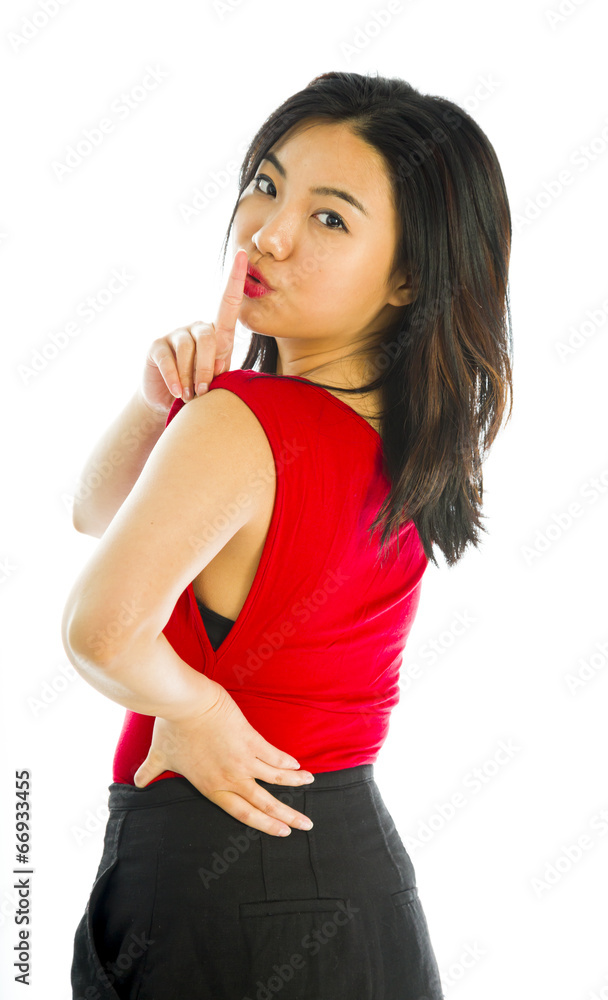 Young woman standing with finger on lips Young woman standing with finger on lips